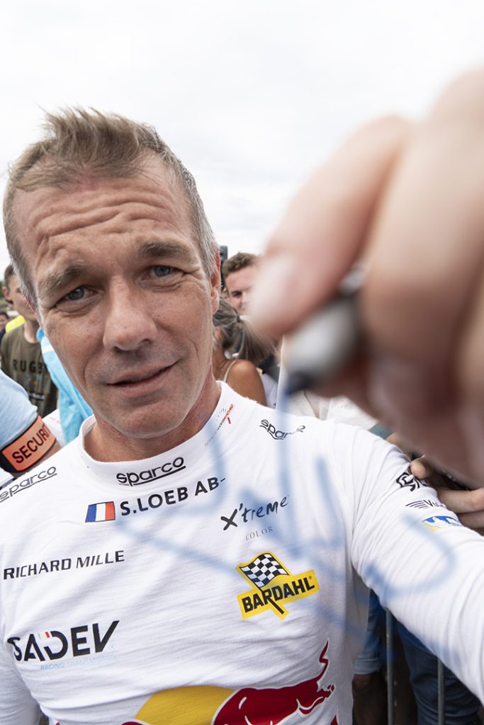 Portrait de Sébastien Loeb dédicaçant l'objectif